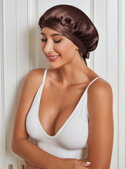 Woman wearing a brown mulberry silk sleep cap with a tie closure, protecting hair.