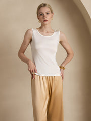 Women's ivory mulberry silk sleeveless tank top with a round neck, paired with gold wide-leg pants.