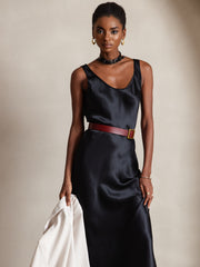 Black mulberry silk U-neck midi dress with a red belt, worn by a woman holding a white jacket.