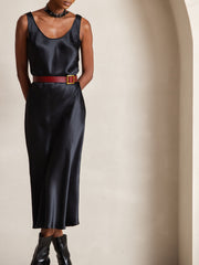 Black 100% mulberry silk U-neck midi dress with a red belt and black boots.