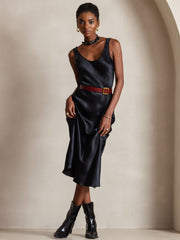 Black mulberry silk sleeveless U-neck midi dress with a brown belt and black boots.
