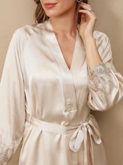 Champagne mulberry silk robe with delicate lace trim on sleeves, tied at the waist.