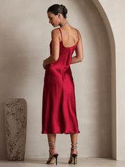 Red mulberry silk spaghetti strap midi dress on a woman, showcasing its elegant drape and shine.