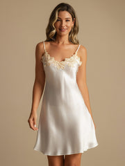 Women's white mulberry silk spaghetti strap nightgown with delicate lace V-neck design.