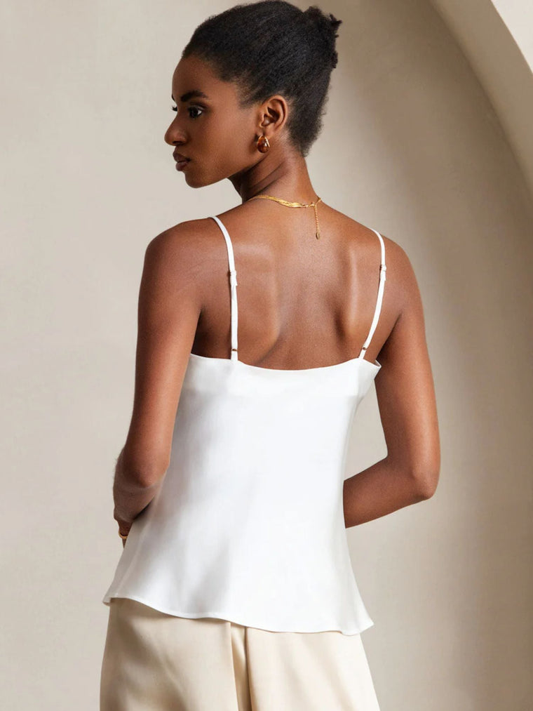 Woman wearing a white mulberry silk spaghetti strap camisole top.