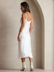 White mulberry silk spaghetti strap V-neck midi dress on a woman, paired with white boots.