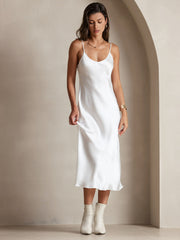 White mulberry silk spaghetti strap V-neck midi dress on a woman, paired with white boots.