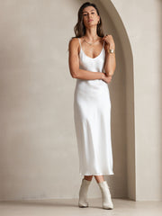 Women's white 100% Mulberry silk spaghetti strap V-neck midi dress with white boots.