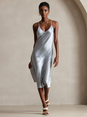 Light blue mulberry silk midi dress with spaghetti straps and V-neck, worn by a woman.