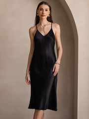 Woman in a black mulberry silk spaghetti strap V-neck midi dress with a subtle sheen.