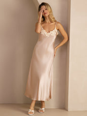 Blonde woman in a blush mulberry silk midi dress with spaghetti straps and delicate lace V-neck design.
