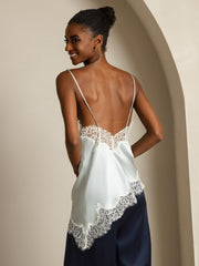 Women's light blue mulberry silk camisole with lace trim, spaghetti straps, and asymmetrical hem.