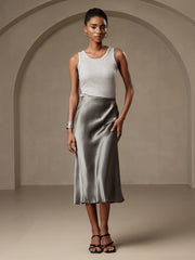 Woman in a dark gray mulberry silk stretch long straight skirt and light gray tank top.