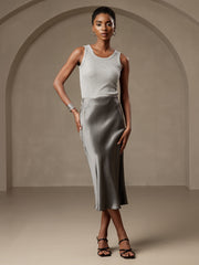 Woman in a gray ribbed tank top and a flowing mulberry silk stretch long straight skirt.