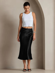 Woman wearing a black mulberry silk stretch long straight skirt with a white tank top.