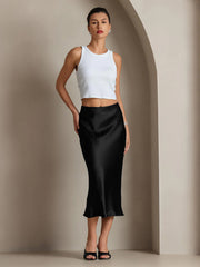 Woman in a black mulberry silk stretch long straight skirt and white tank top.