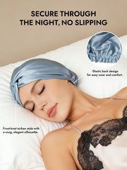 Blue mulberry silk turban with front-knot style and elastic back, worn by a woman sleeping.