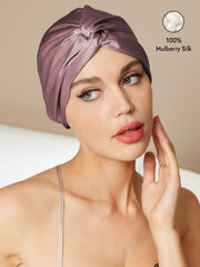 Pale mauve 100% mulberry silk turban for sleeping with a knot-front style, worn by a woman.