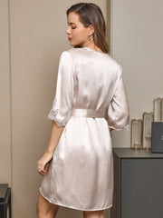 Women's blush pink mulberry silk robe with lace trim on sleeves and a tie waist.