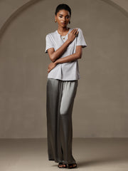 Woman in grey mulberry silk wide leg pants with elastic waist and a light grey top.