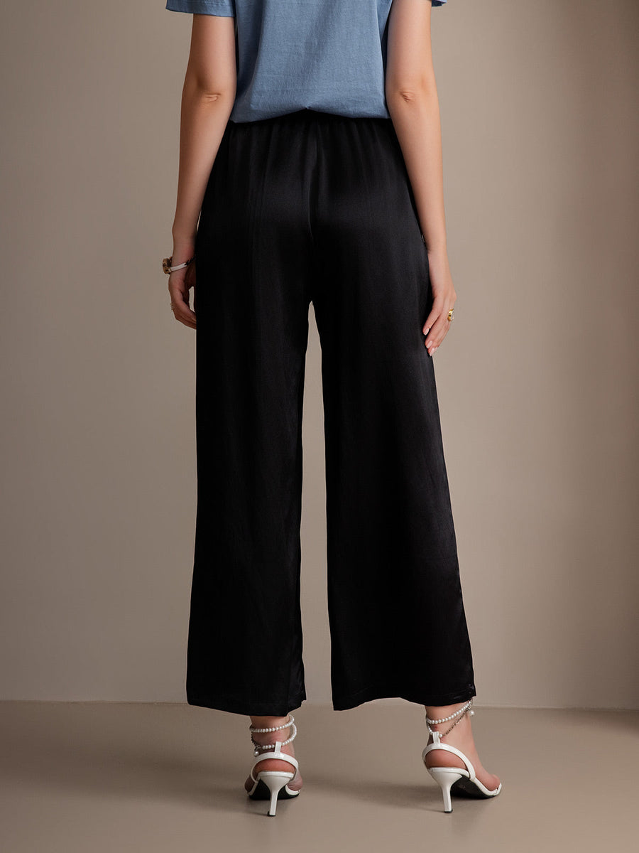Black mulberry silk wide-leg women's pants with elastic waist, paired with white heels.