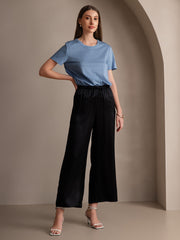 Woman wearing black mulberry silk wide-leg pants with elastic waist and a blue t-shirt.