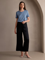 Woman wearing black 100% Mulberry silk wide-leg pants with an elastic waist and a blue t-shirt.