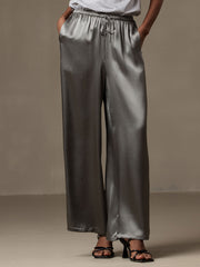 Dark gray 100% mulberry silk wide-leg women's pants with elastic waist and drawstring, worn with black heels.