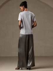 Woman in gray mulberry silk wide-leg pants with elastic waist and a light gray top.