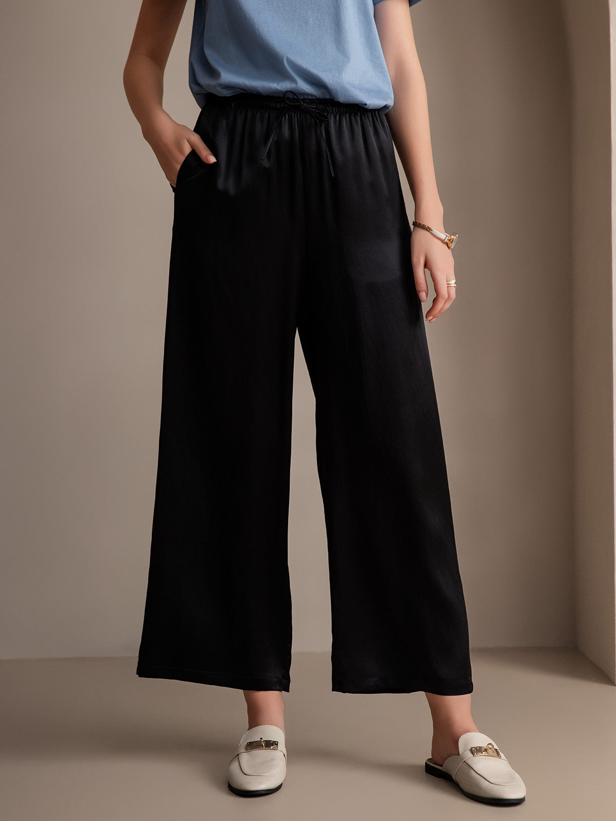 Black 100% mulberry silk wide-leg women's pants with elastic waist and pockets.