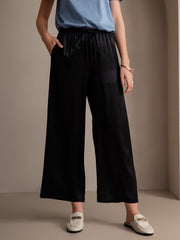 Black 100% mulberry silk wide-leg women's pants with elastic waist and pockets.