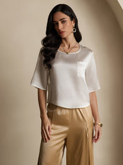 Women's white mulberry silk short sleeve boxy crop top with pocket, paired with gold silk pants.