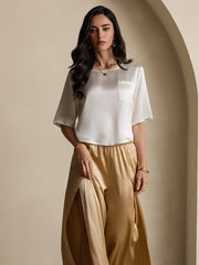 Women's white mulberry silk short sleeve boxy crop top with pocket, paired with gold silk wide-leg pants.