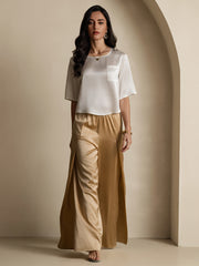 Women's white mulberry silk boxy crop top with short sleeves and pocket, paired with gold silk wide-leg pants.