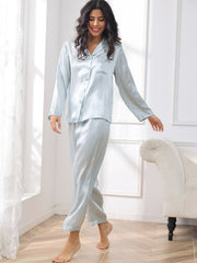 Women's light blue mulberry silk long sleeve pajamas set with button-down top and matching pants.