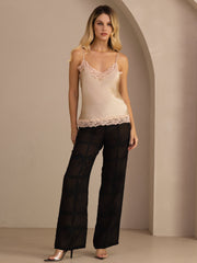 Women's champagne mulberry silk camisole top with V-neck and pink lace trim, paired with black sheer pants.
