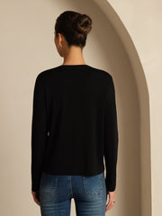 Woman in black mulberry silk V-neck long sleeve basic cardigan and jeans, back view.