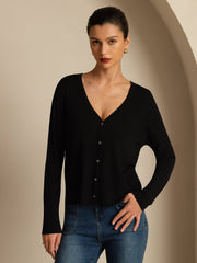 Women's black mulberry silk V-neck long sleeve cardigan with buttons, paired with blue jeans.