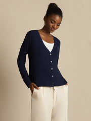 Women's navy blue mulberry silk V-neck long sleeve cardigan with white buttons, worn over a white top.