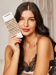 Woman holding a bundle of 10 pure silk skinny hair scrunchies in a light champagne color.