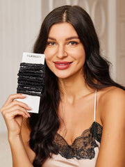 Smiling woman holds a bundle of 10 black pure mulberry silk skinny hair scrunchies, 1cm wide.