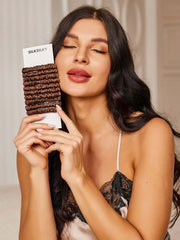 Woman holding a bundle of 10 pure mulberry silk skinny scrunchies in brown, 1cm wide.