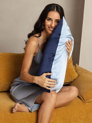 Smiling woman holds a two-tone 19Momme mulberry silk pillowcase in navy and light blue.