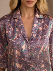 Women's pink mulberry silk short sleeve button-up top with a purple palm tree print.