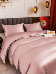Pink 19 Momme mulberry silk duvet cover set with two pillowcases on a bed.