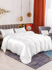White 19 Momme mulberry silk duvet cover set with two pillowcases on a bed.