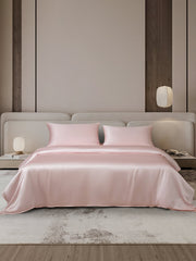 Pink 19 Momme mulberry silk duvet cover set with two pillowcases on a bed.