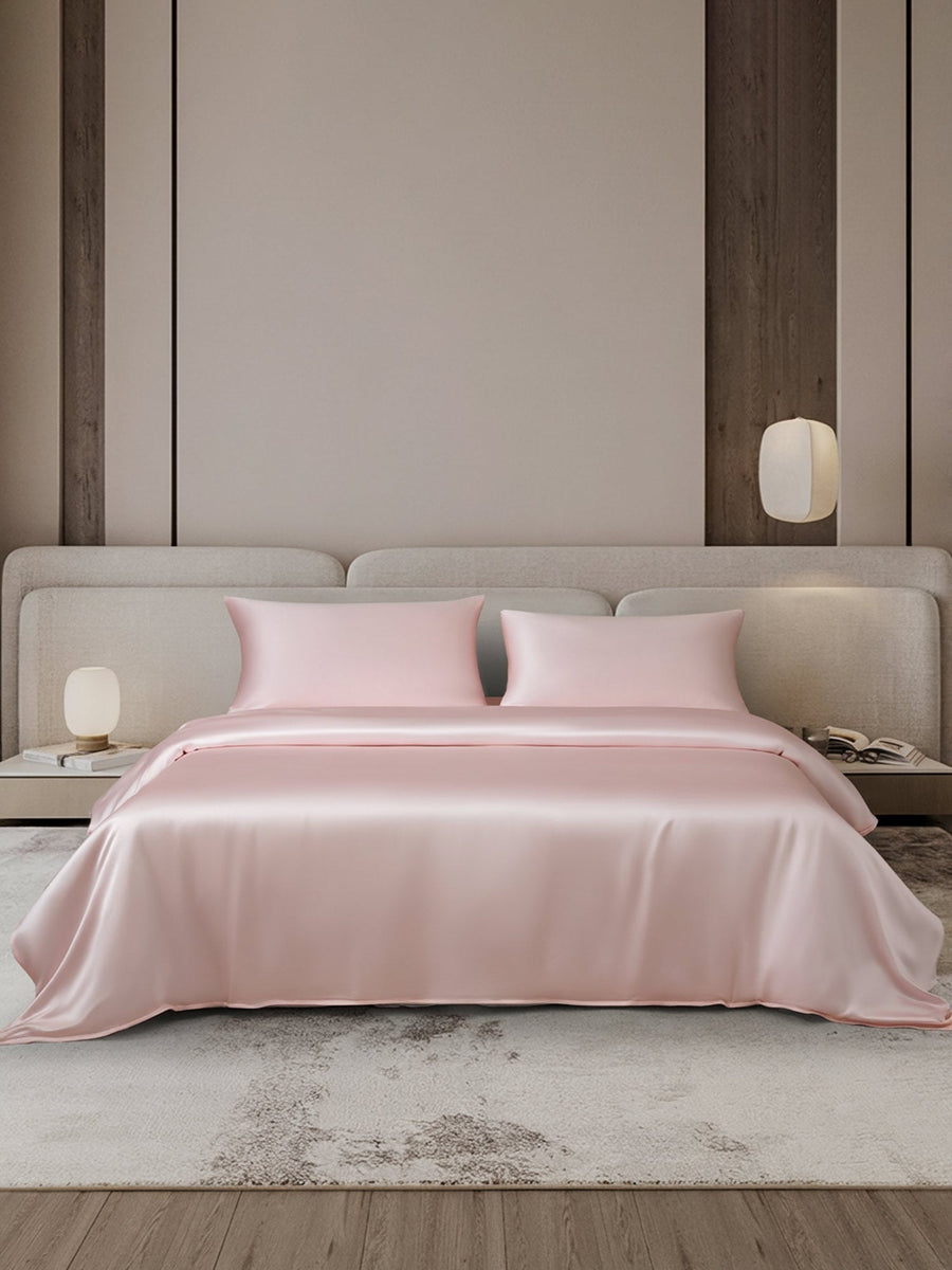 Pink 19 Momme mulberry silk duvet cover set with two pillowcases on a bed.