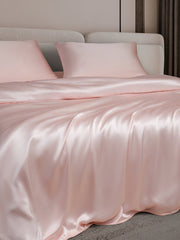 Pink 19 Momme mulberry silk duvet cover and two pillowcases on a bed.