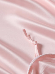 Soft pink 19 Momme mulberry silk duvet cover with a tied ribbon detail and subtle sheen.